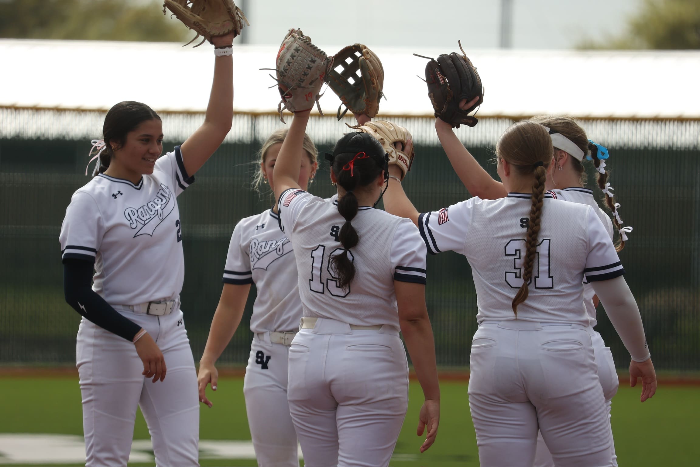 Smithson Valley teammates raise their gloves in unity during a pregame huddle at home field in Spring Branch, Texas. The Rangers captured the 2024 district championship and are aiming for a deep playoff run.