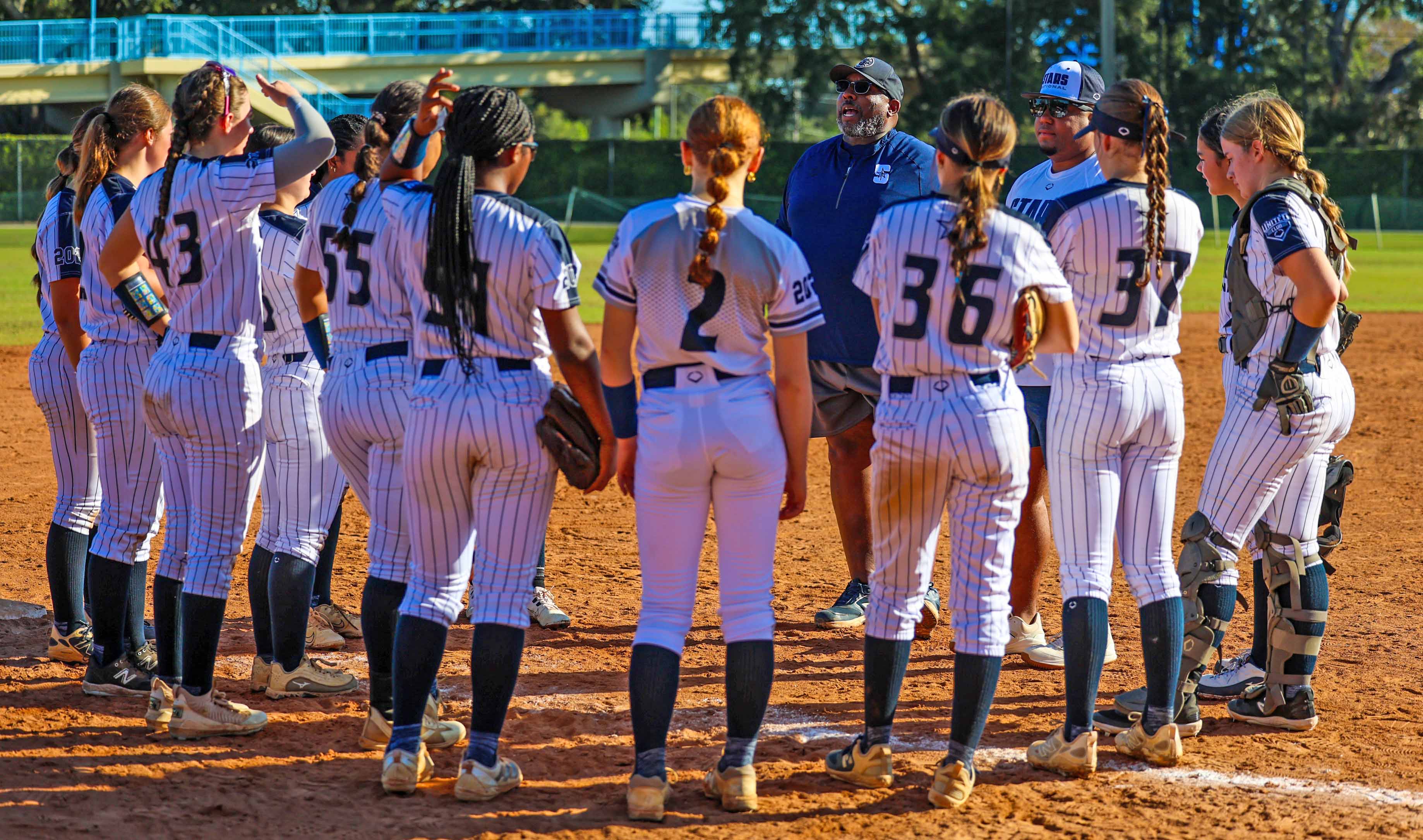 Players meet with coaches between innings during tournament play.